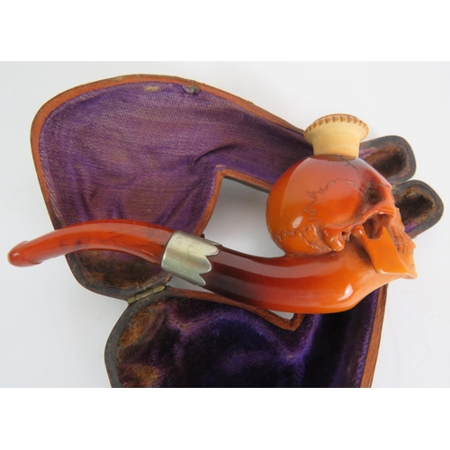 87 - A 19th Century carved Meerschaum cheroot pipe holder carved in the form of a human skull, amber mout... 