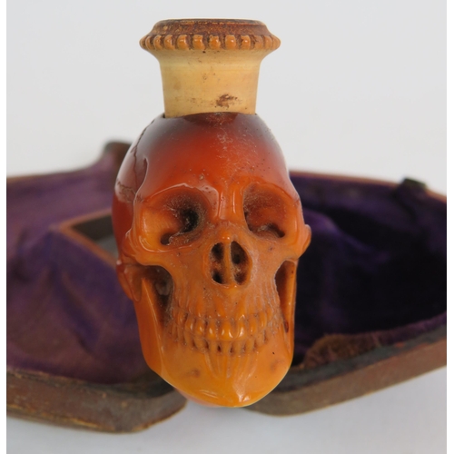 87 - A 19th Century carved Meerschaum cheroot pipe holder carved in the form of a human skull, amber mout... 