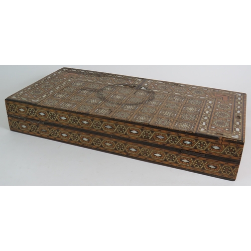 91 - An inlaid Damascus Ware games box with backgammon board interior and chess board exterior. Bone coun... 