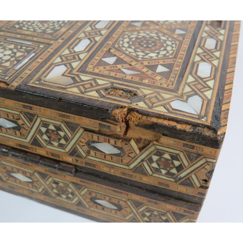 91 - An inlaid Damascus Ware games box with backgammon board interior and chess board exterior. Bone coun... 