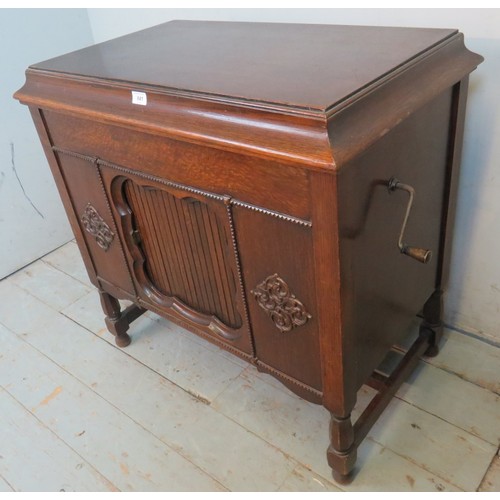 841 - A 1920's oak cased freestanding gramophone by Gilbert with applied moulded decoration to case and ta... 