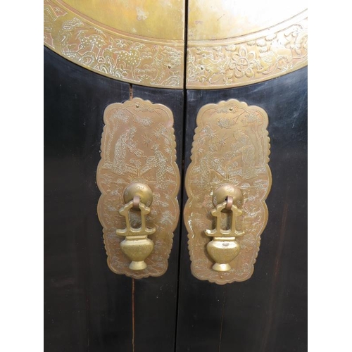 714 - A 20th century Chinese black lacquered elm marriage cabinet, the double doors opening to reveal thre... 