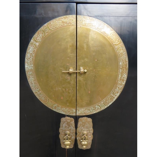 714 - A 20th century Chinese black lacquered elm marriage cabinet, the double doors opening to reveal thre... 