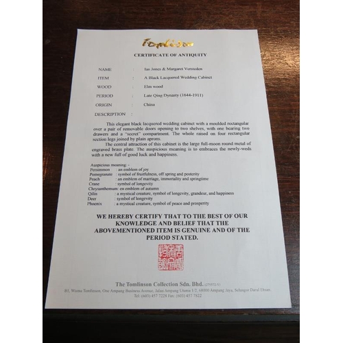 714 - A 20th century Chinese black lacquered elm marriage cabinet, the double doors opening to reveal thre... 