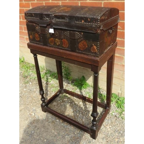 723 - An 18th century dome topped leather covered casket with brass studwork and painted fruit decoration,... 