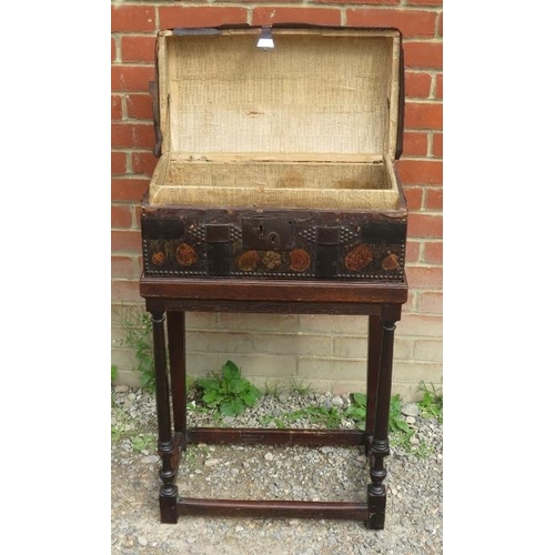 723 - An 18th century dome topped leather covered casket with brass studwork and painted fruit decoration,... 