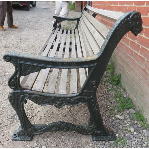 743 - A large cast iron park bench with teak slatted seat and heavy end supports depicting lions heads, vi... 