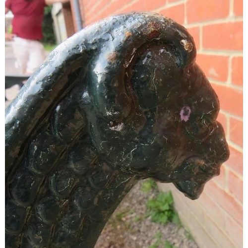 743 - A large cast iron park bench with teak slatted seat and heavy end supports depicting lions heads, vi... 