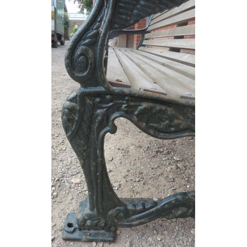 743 - A large cast iron park bench with teak slatted seat and heavy end supports depicting lions heads, vi... 