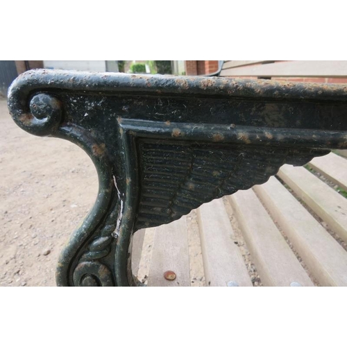743 - A large cast iron park bench with teak slatted seat and heavy end supports depicting lions heads, vi... 