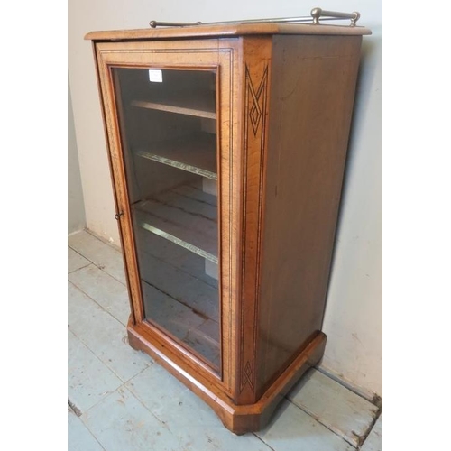 754 - A Victorian walnut parquetry inlaid music cabinet with brass gallery rail and glazed door opening on... 
