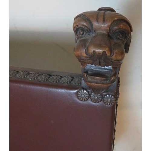 773 - A vintage mahogany Savonarola chair ornately carved with grotesque mask finials & armrests, raised o... 