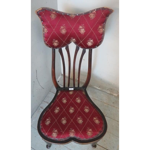 776 - An Art Nouveau occasional chair with unusually shaped back rest and seat upholstered in claret gold ... 