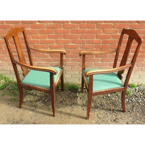 883 - A pair of Edwardian oak framed high back armchairs, with lift out green seat pads, raised on taperin... 