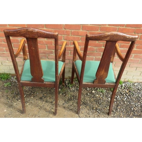 883 - A pair of Edwardian oak framed high back armchairs, with lift out green seat pads, raised on taperin... 