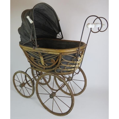 117 - A Victorian style doll's pram with rattan cane basket. Steel frame, porcelain handles and wood frame... 