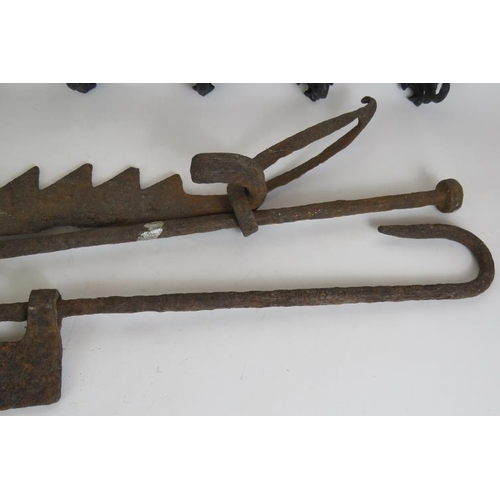 129 - Two ornate cast iron coat racks, both 45cm long, plus two old iron fire trammel pot hangers. (4).
Co... 