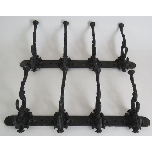 129 - Two ornate cast iron coat racks, both 45cm long, plus two old iron fire trammel pot hangers. (4).
Co... 