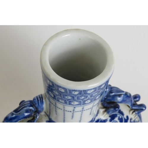 13 - An antique Chinese porcelain moon vase decorated in blue and white with applied dragon handles and f... 