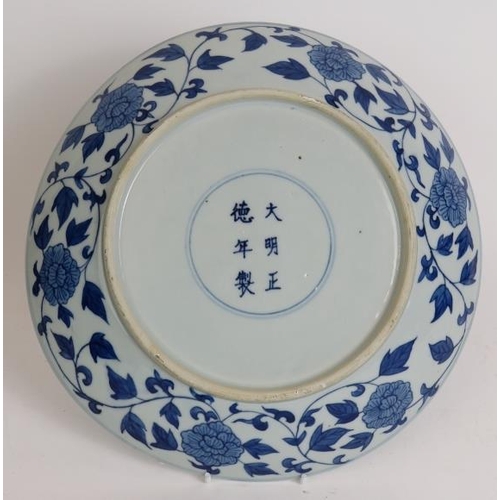 15 - An antique Chinese porcelain blue and white charger depicting a pearl chasing dragon within a four d... 