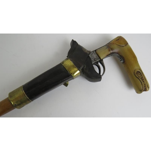 21 - An antique Wrythen shafted walking stick with percussion muff pistol handle, c1820. The octagonal ba... 