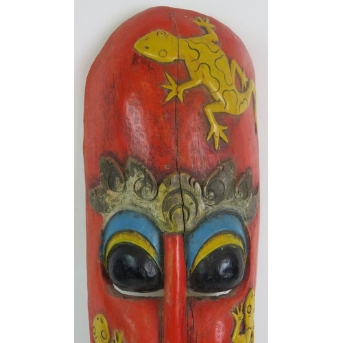 3 - A hand carved Indonesian tribal mask with aged painted decoration and slit cut eye and mouth holes. ... 