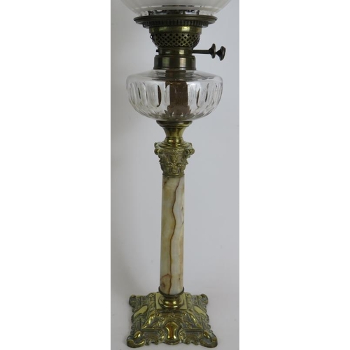 37 - A tall antique oil lamp standing on a white onyx and brass Corinthian column base with oilive cut cl... 