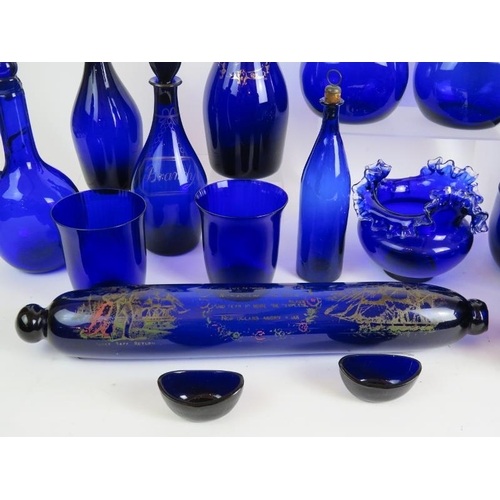 38 - 22 pieces of mainly antique Bristol blue glass including 2 gilded decanters, a decorated rolling pin... 