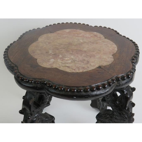 7 - An antique Chinese rosewood low pot stand with inset pink marble top within a scalloped surround wit... 