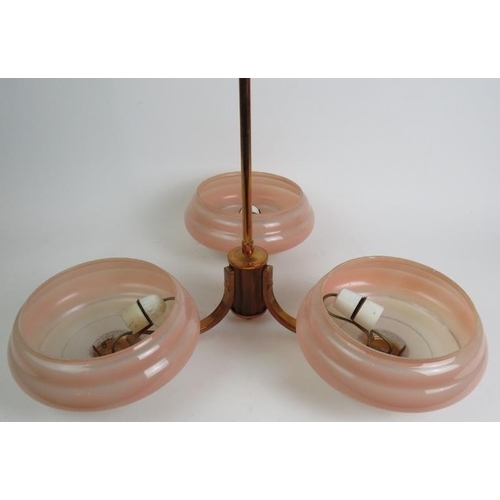 73 - A period Art Deco three branch ceiling light in polished copper with pink glass shades. Overall heig... 