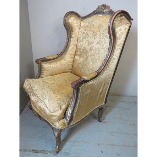 701 - An antique 18th century French style giltwood wingback armchair in a Louis XVI taste, the ornately c... 