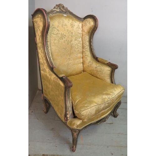 701 - An antique 18th century French style giltwood wingback armchair in a Louis XVI taste, the ornately c... 