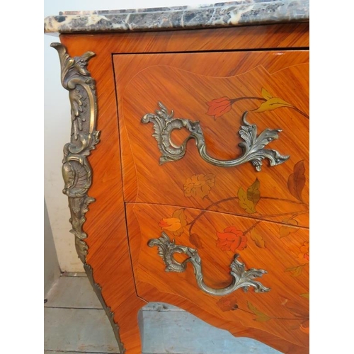 703 - A reproduction 19th century style French tulipwood commode chest featuring black serpentine marble t... 