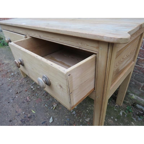 715 - An antique pine sideboard with rounded corners, housing two deep drawers with turned wooden knob han... 