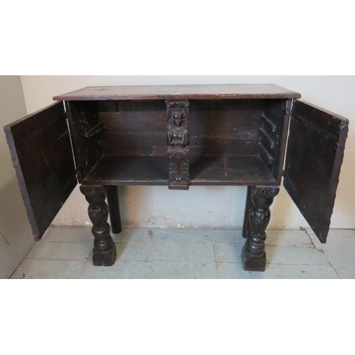 716 - An antique oak sideboard, composed of ornately carved 17th century elements, with two cupboard doors... 