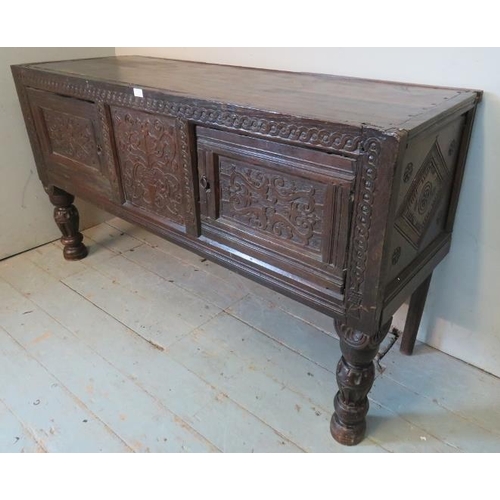 717 - A large antique oak sideboard composed of ornately carved 17th century elements, featuring carved fr... 