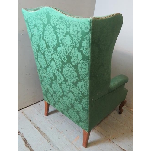 719 - A 19th century wingback armchair upholstered in sage green damask fabric, raised on fruitwood cabrio... 