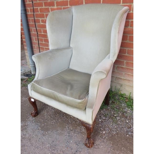 733 - A vintage Georgian style wingback armchair upholstered in a pale green draylon fabric raised on maho... 