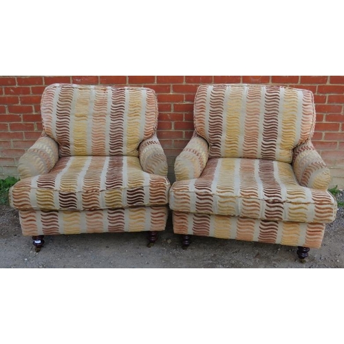 734 - A pair of contemporary low and deep armchairs in the manner of Howard & Sons, upholstered in a multi... 