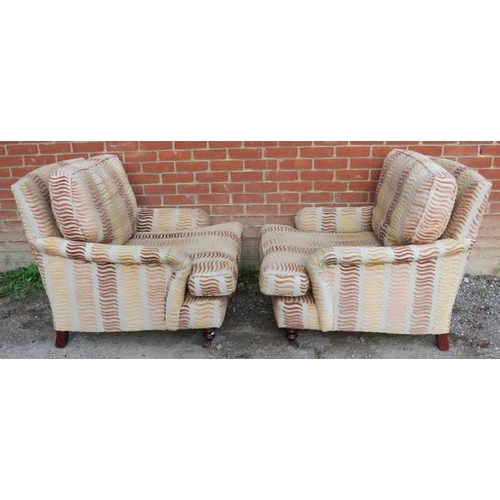 734 - A pair of contemporary low and deep armchairs in the manner of Howard & Sons, upholstered in a multi... 