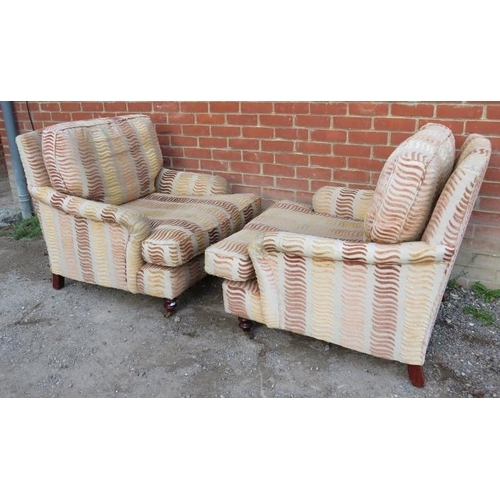 734 - A pair of contemporary low and deep armchairs in the manner of Howard & Sons, upholstered in a multi... 