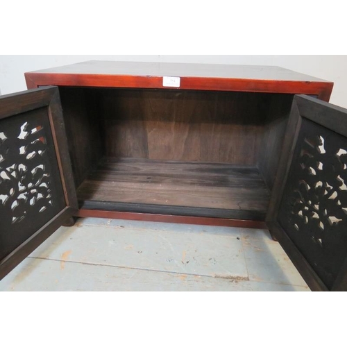 754 - A Korean stained elm low side cabinet with carved & pierced doors depicting foliate motifs, raised o... 