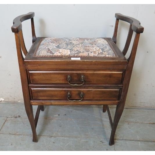 777 - An Edwardian mahogany piano stool with shaped armrests & tapestry seat, containing two fall front dr... 