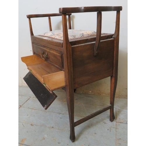 777 - An Edwardian mahogany piano stool with shaped armrests & tapestry seat, containing two fall front dr... 