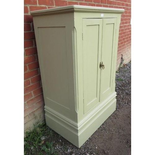 807 - An antique pine cabinet painted pale green with two fitted shelves & brass catch handle, raised on p... 