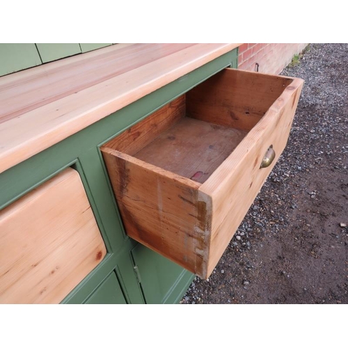 808 - An antique pine kitchen dresser painted green with plate rack shelving over a sideboard base contain... 