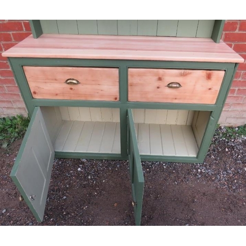 808 - An antique pine kitchen dresser painted green with plate rack shelving over a sideboard base contain... 