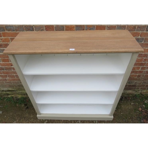 810 - A low open bookcase containing three fitted shelves painted light green with light oak top, raised o... 