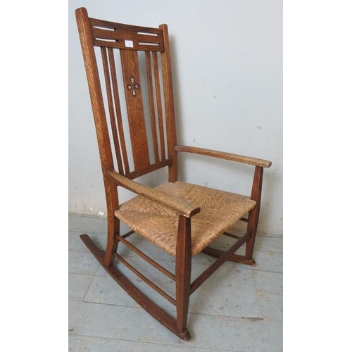 813 - An Arts & Crafts medium oak rocking chair with rush seat & inlaid back splat.
Condition report: No i... 