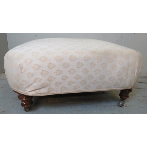 821 - A Victorian mahogany sprung footstool upholstered in a cream patterned fabric, raised on tapering tu... 